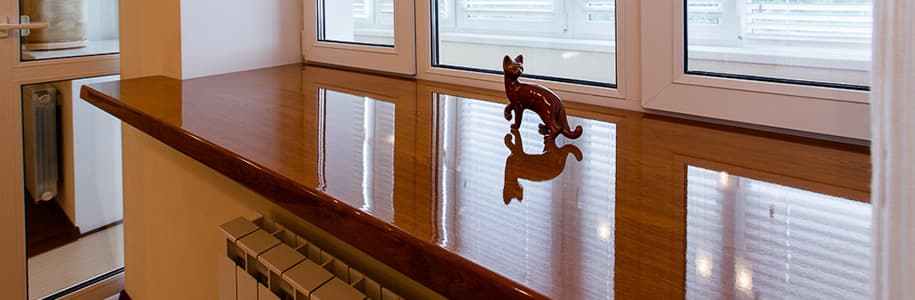 Широкий подоконник с коричневой глянцевой поверхностью